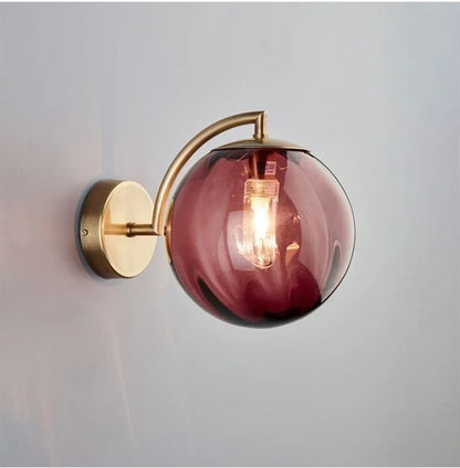 A Curved Brass Arm Holds a Glass Globe