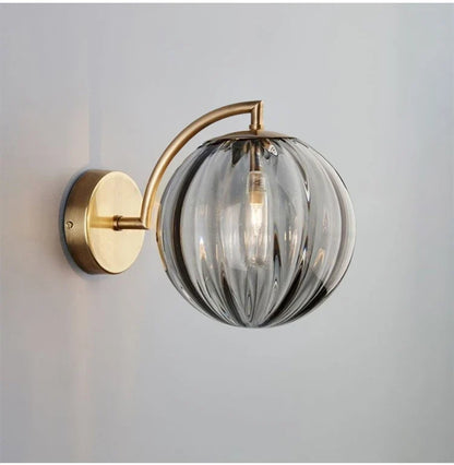 A Curved Brass Arm Holds a Glass Globe
