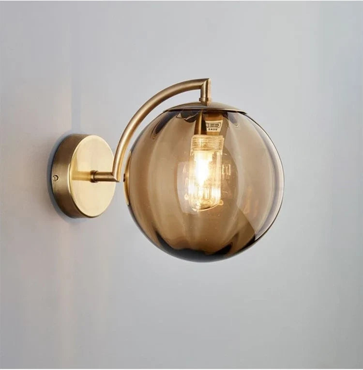 A Curved Brass Arm Holds a Glass Globe