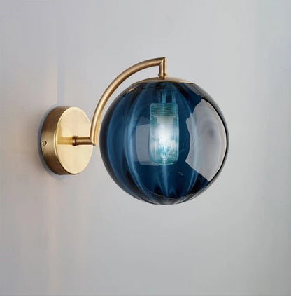 A Curved Brass Arm Holds a Glass Globe