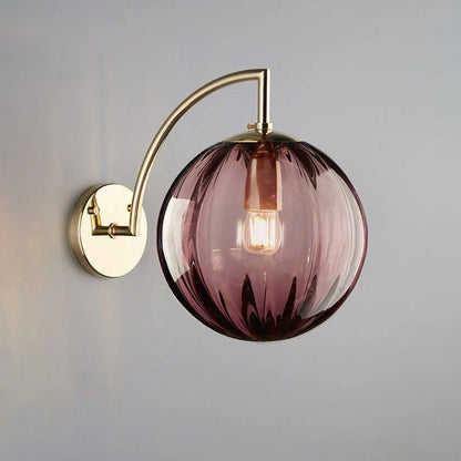 A Curved Brass Arm Holds a Glass Globe