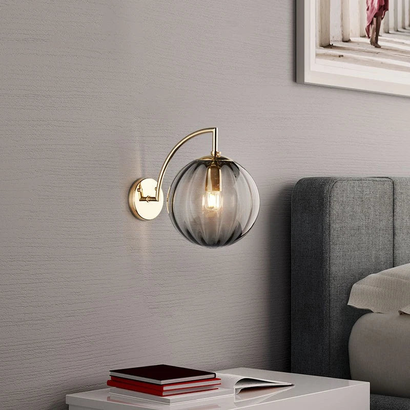 A Curved Brass Arm Holds a Glass Globe