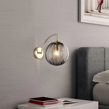A Curved Brass Arm Holds a Glass Globe