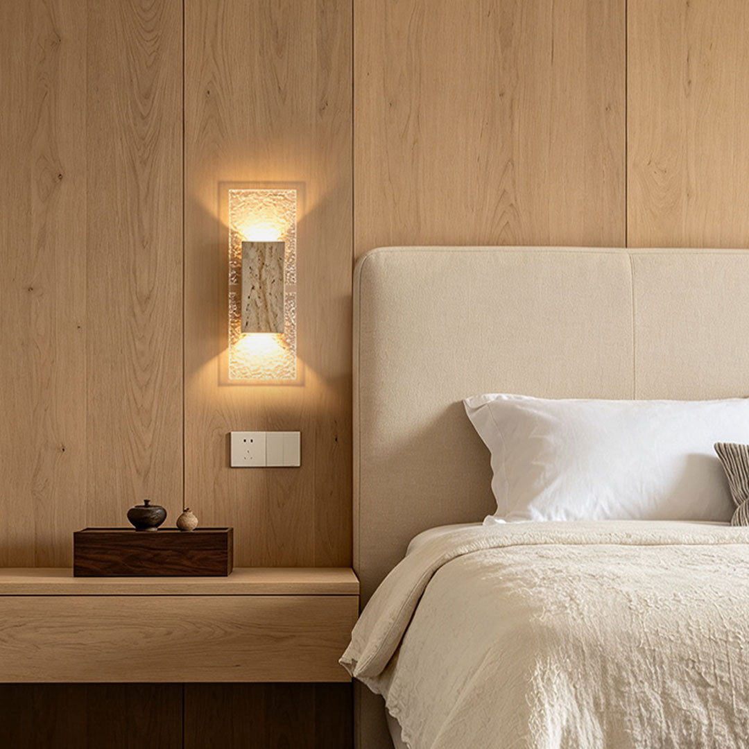 Indoor wall sconce up and down light mounted beside a bed, creating warm ambient lighting in a modern bedroom.