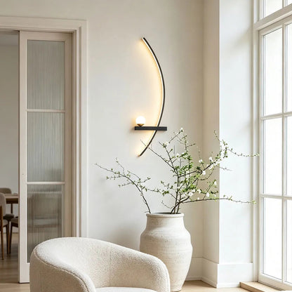 LED curved wall light mounted in a bright corner seating area with a soft warm glow and sculptural form.