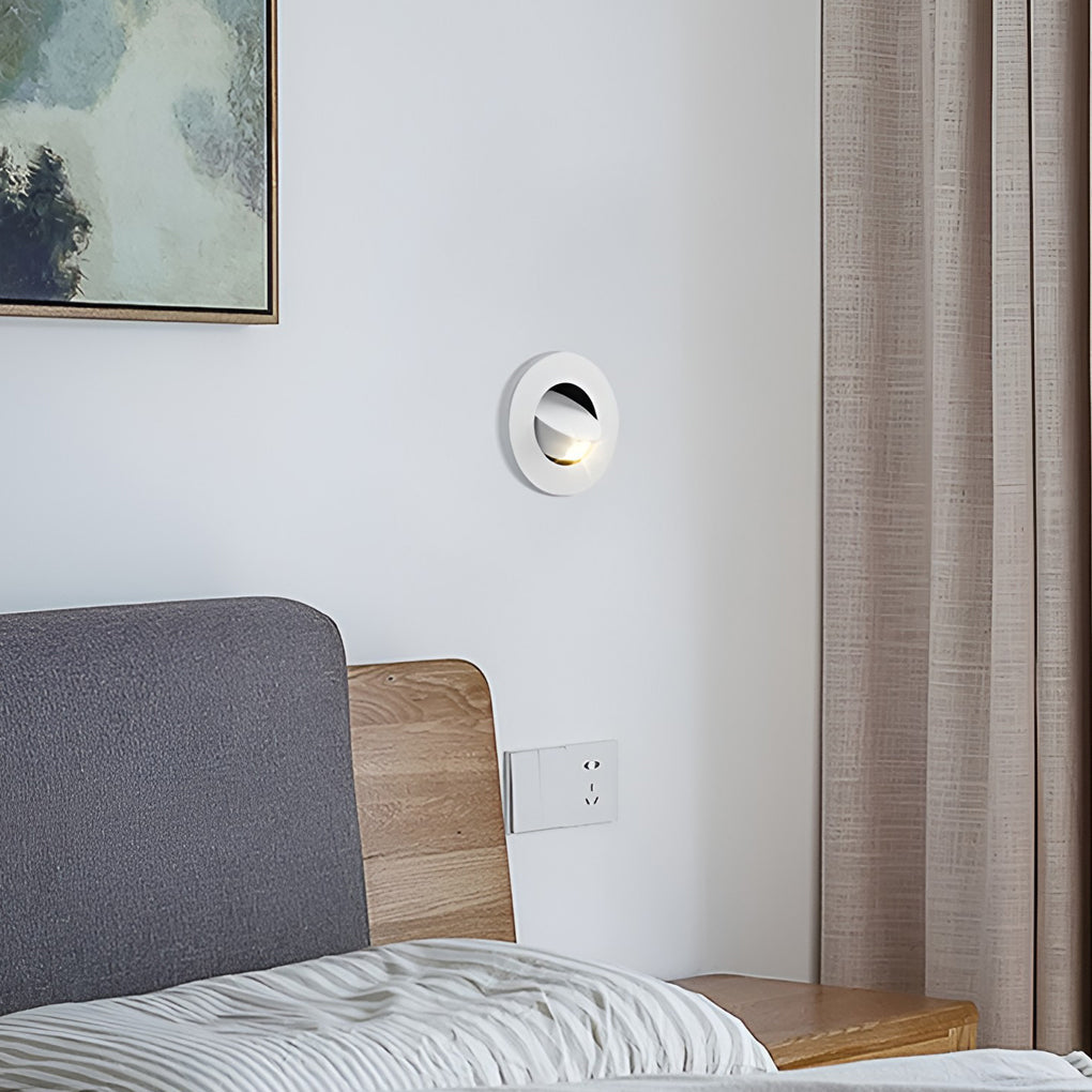 Minimalist bedside wall equipped with recessed led reading lamp for nighttime reading.