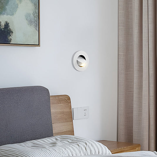 Minimalist bedside wall equipped with recessed led reading lamp for nighttime reading.