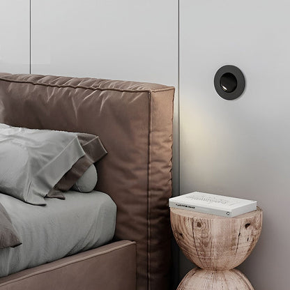 Contemporary bedroom corner featuring black recessed led reading lamp wall installation.