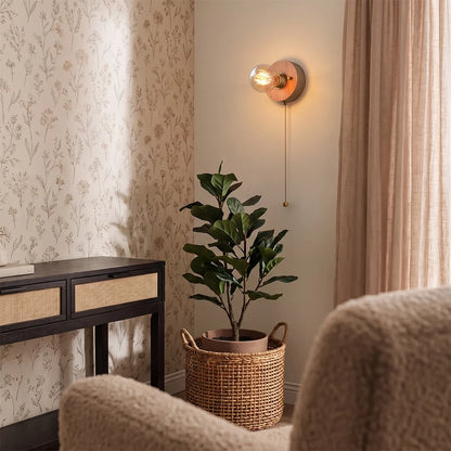 Retro bedside wall light illuminating a cozy corner with a plant, sideboard, and soft furnishings.