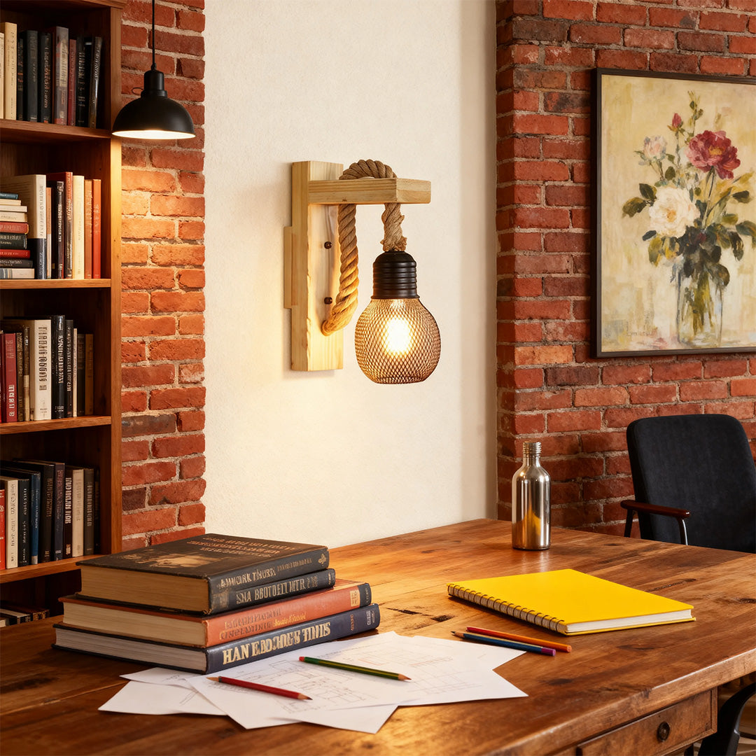 Rustic wall light fixture illuminating a wooden desk in a home office or study with a classic red brick wall backdrop.