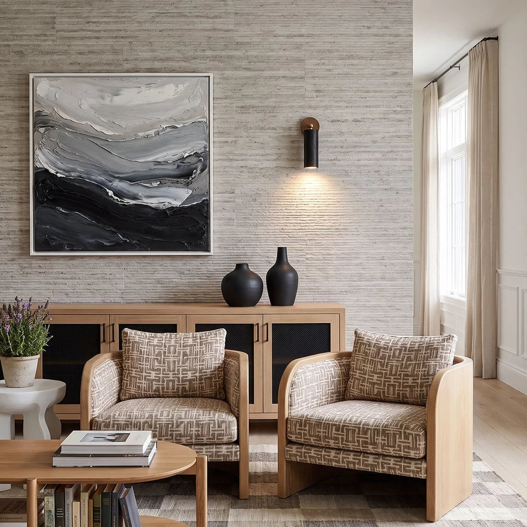 Spotlight wall lights installed above patterned lounge chairs in a bright contemporary living room.