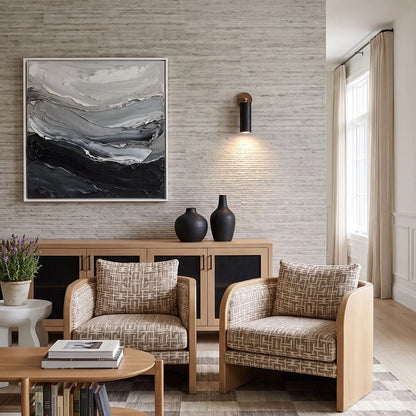 Spotlight wall lights installed above patterned lounge chairs in a bright contemporary living room.