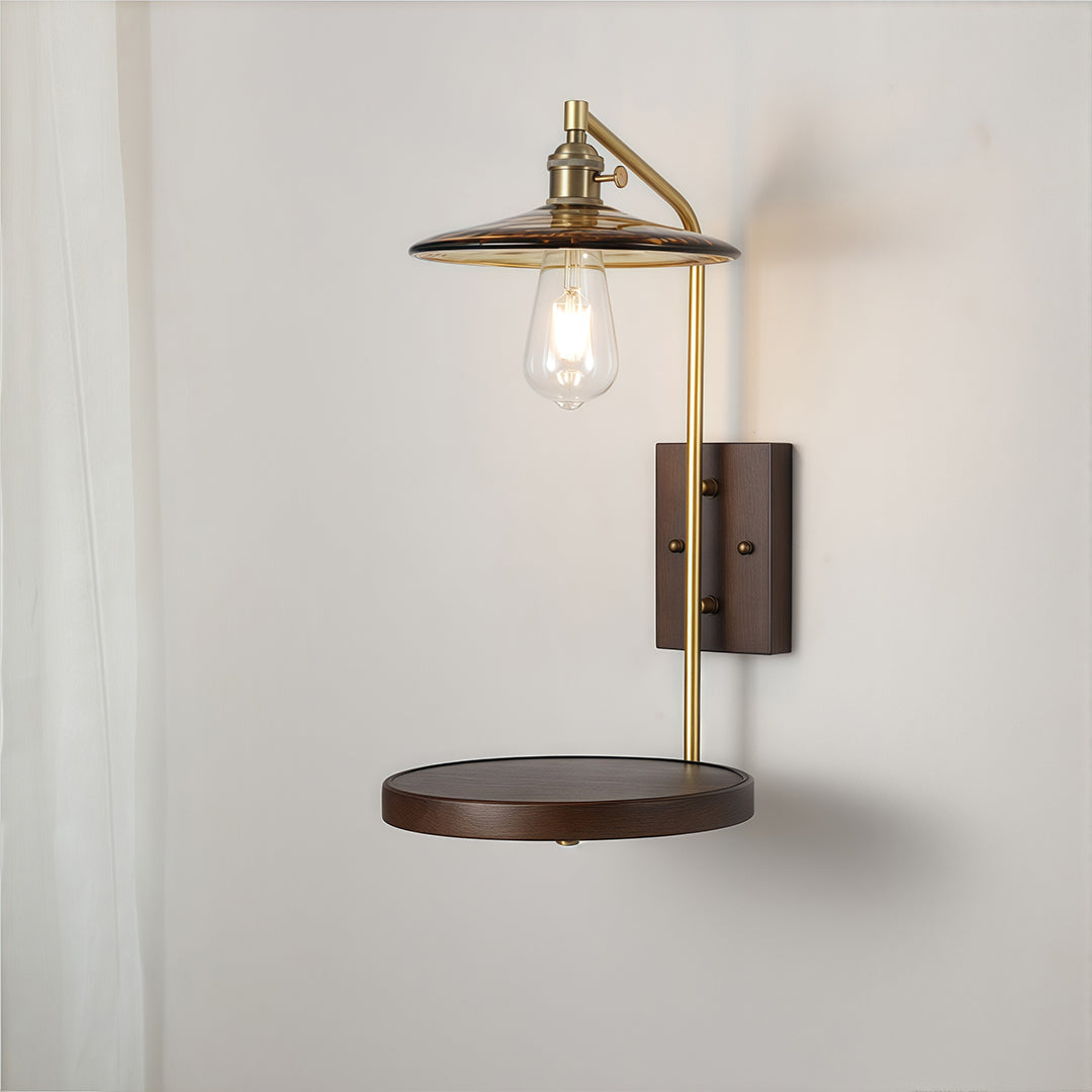 Traditional brass and glass wall lights with a dark wood backplate and integrated floating shelf for bedside use.